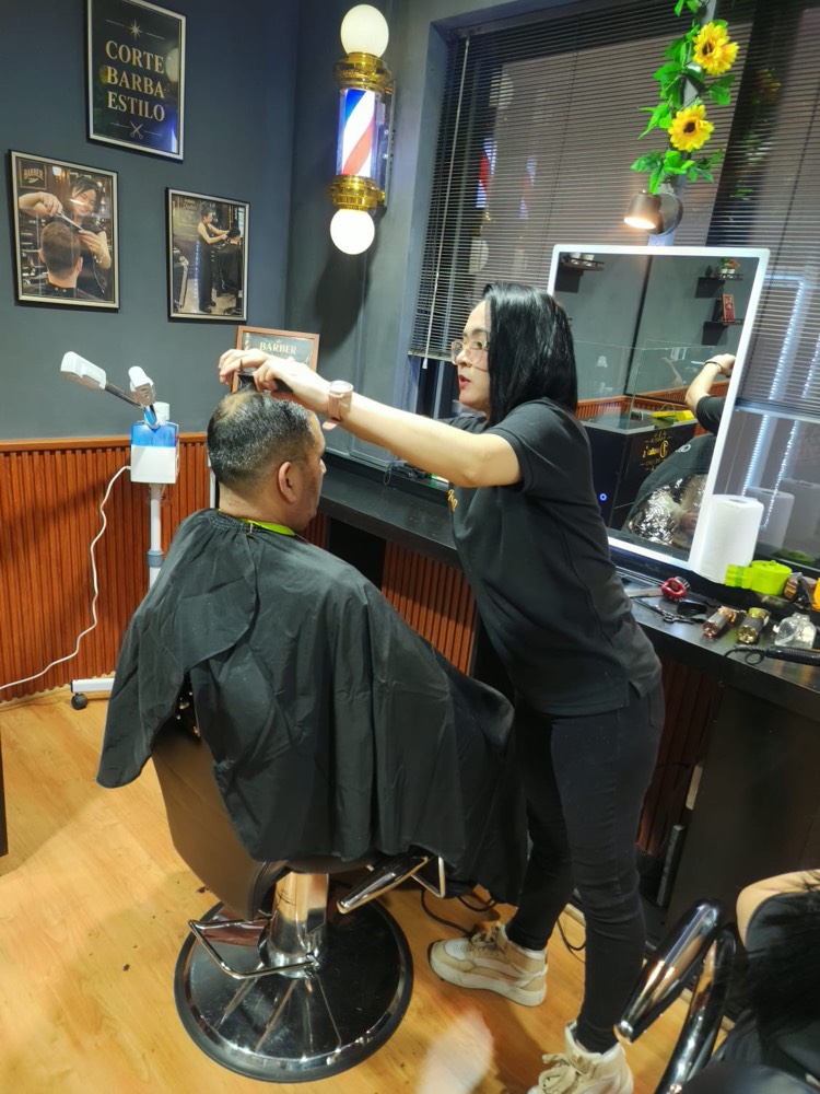 Barbera realizando un corte con tijera y peine